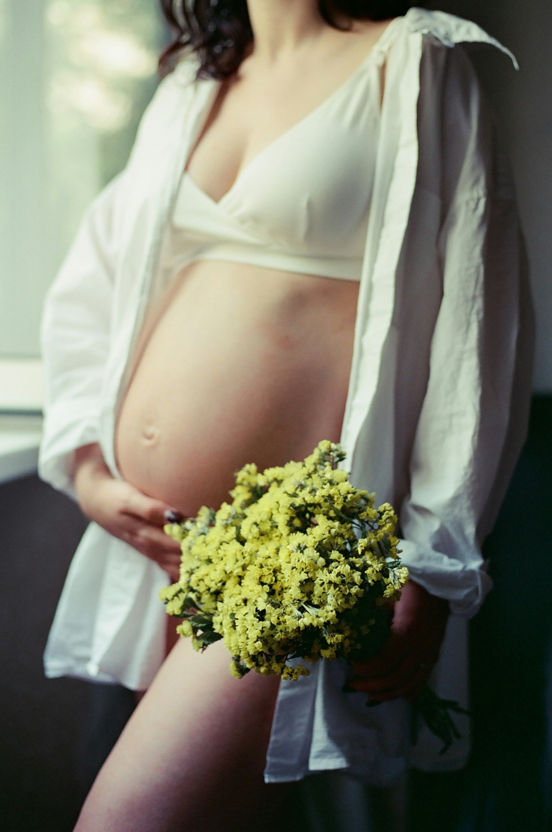 A pregnant woman holding a bouquet of flowers