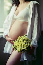 A pregnant woman holding a bouquet of flowers