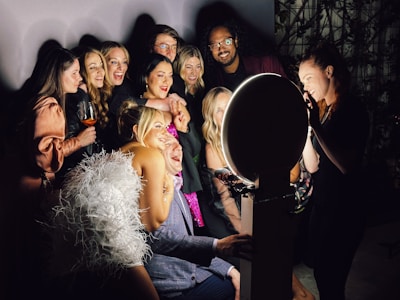 A group of people standing next to each other in front of a photo booth