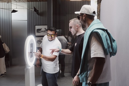 A group of people standing around a mirror