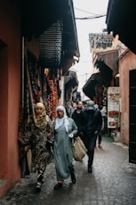 A group of people walking down a narrow street