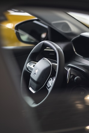 A close up of a steering wheel and dashboard of a car