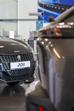 A couple of cars are parked in a showroom