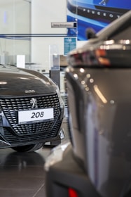 A couple of cars are parked in a showroom