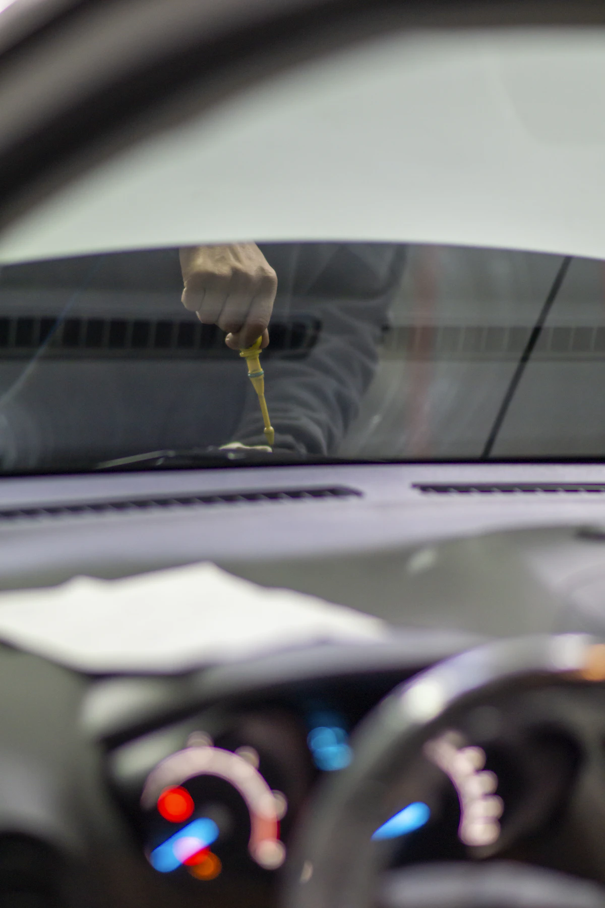 Meistras dirba prie automobilio priekinio stiklo krašto