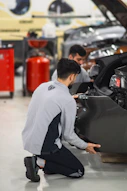 Two men working on a car in a garage