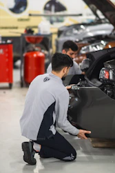 Two men working on a car in a garage