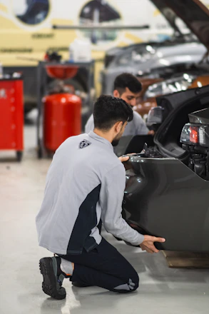 Two men working on a car in a garage