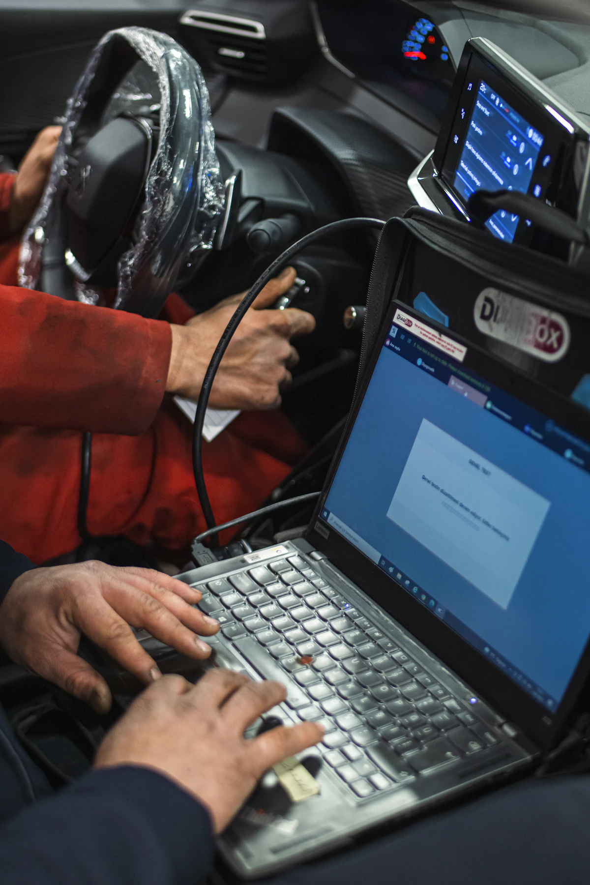 Technician performing vehicle diagnostics with OEM scan tool