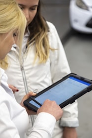 Two women are looking at a tablet screen