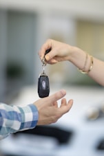 A person handing a car key to another person