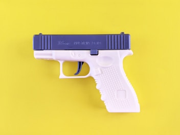 A toy gun on a yellow background