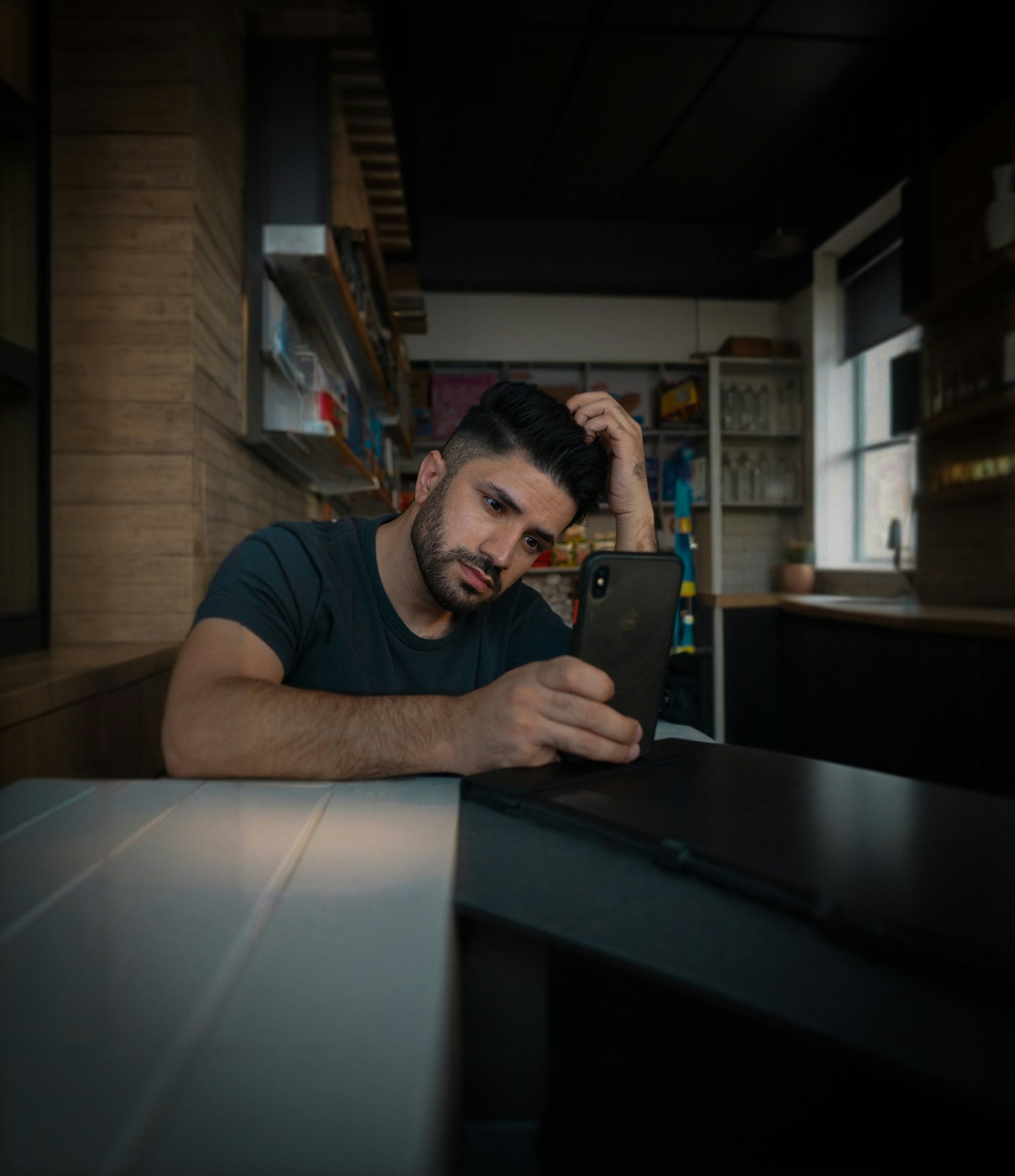 A man sitting at a table looking at a tablet