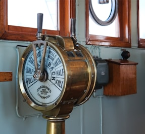 A clock on a pole in front of a window