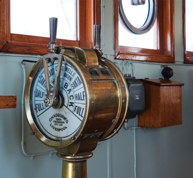 A clock on a pole in front of a window