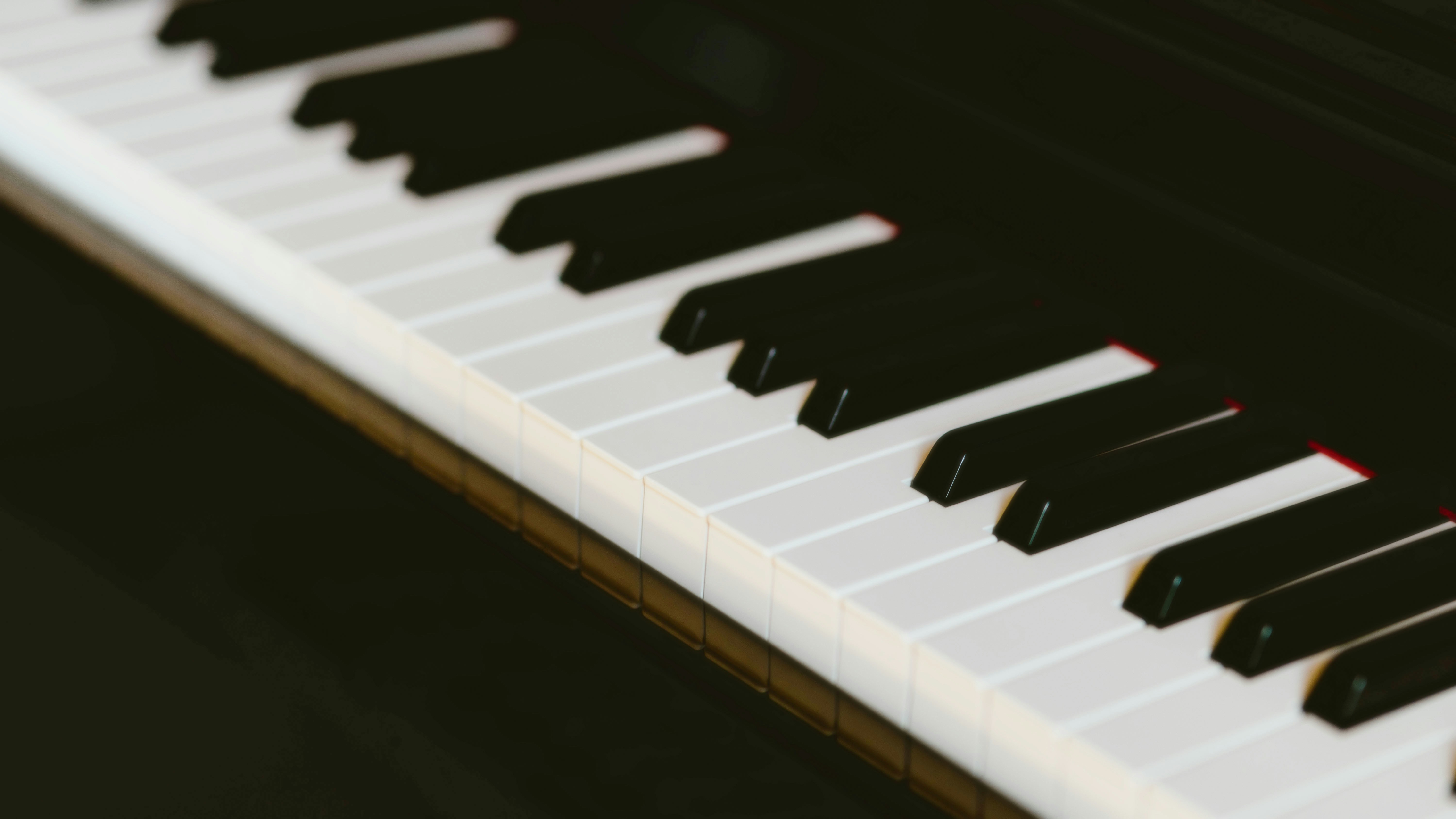 A close up of a piano with black and white keys