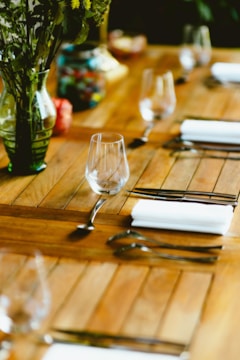 A wooden table topped with lots of place settings