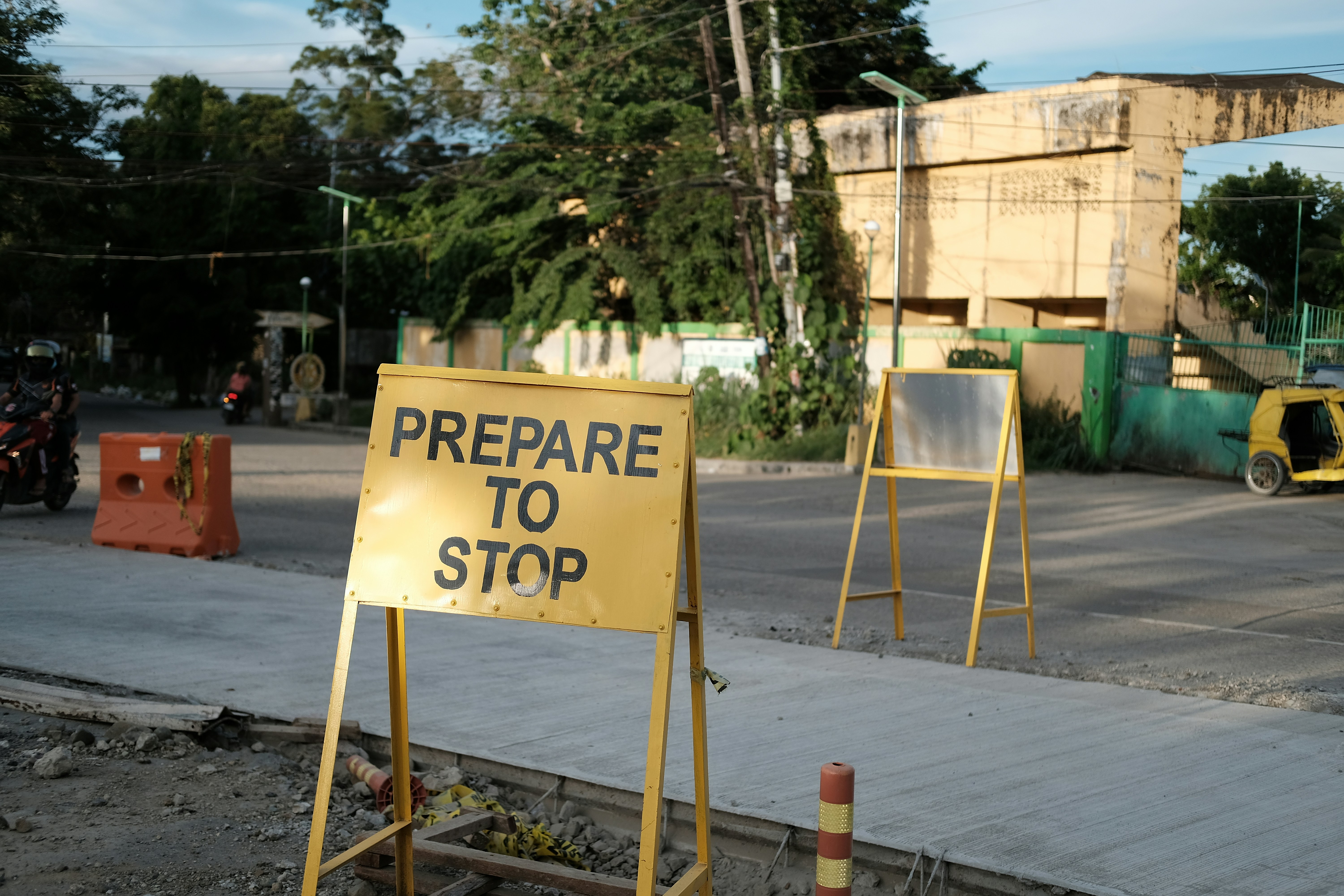 Road under construction. A yellow sign on a metal stand reads \