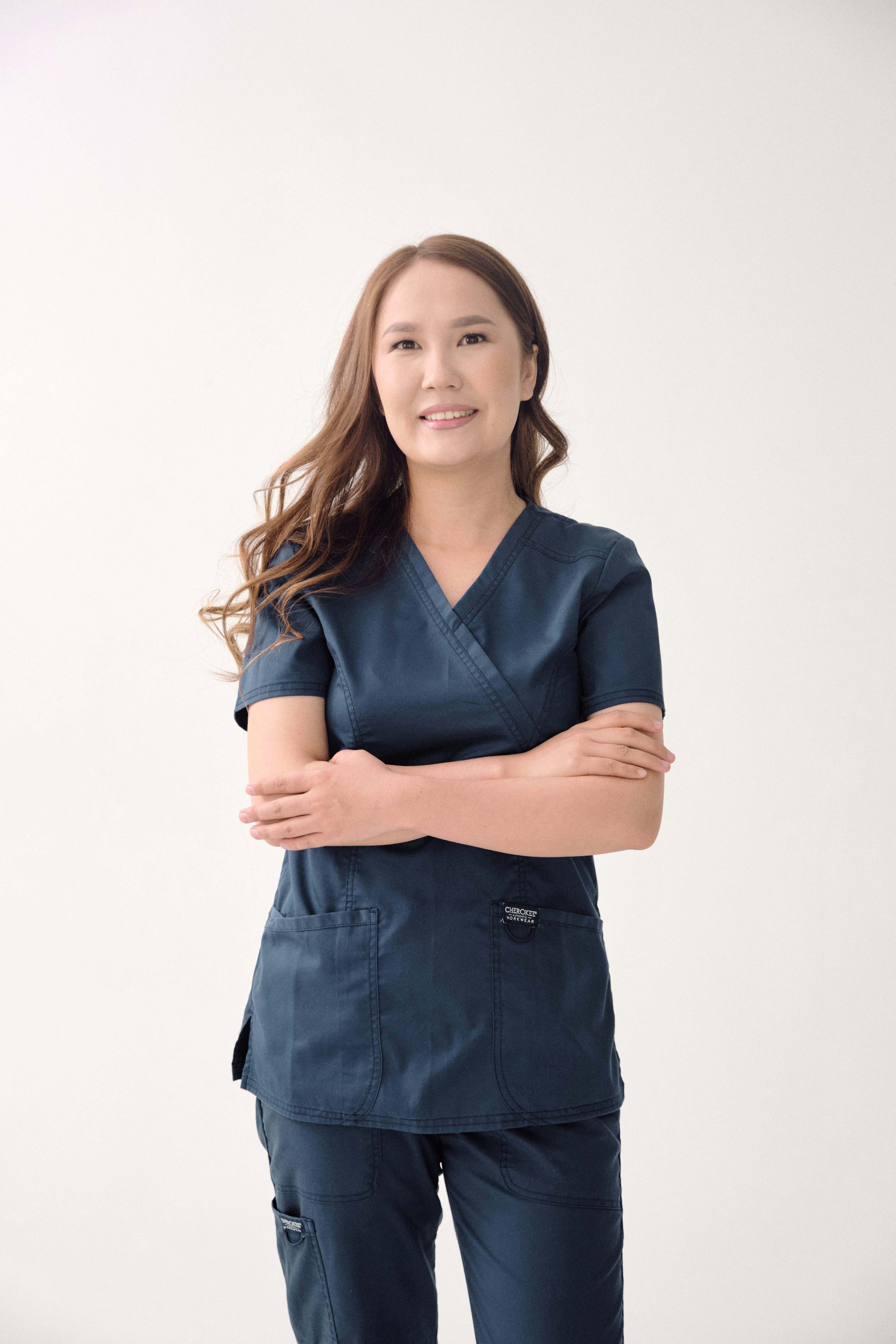 A woman in scrubs standing with her arms crossed photo – Free Woman ...