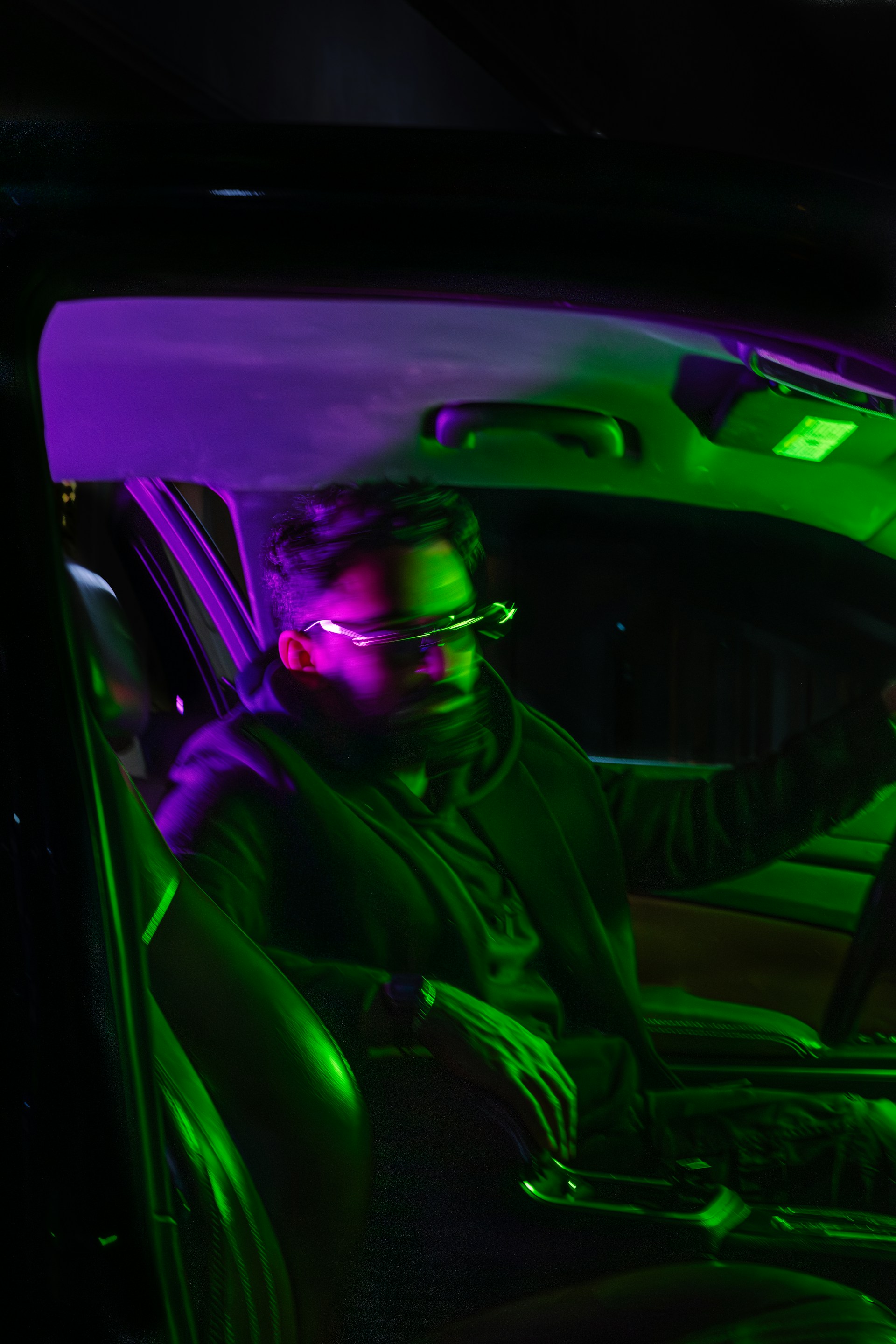 A man sitting in a car with headphones on