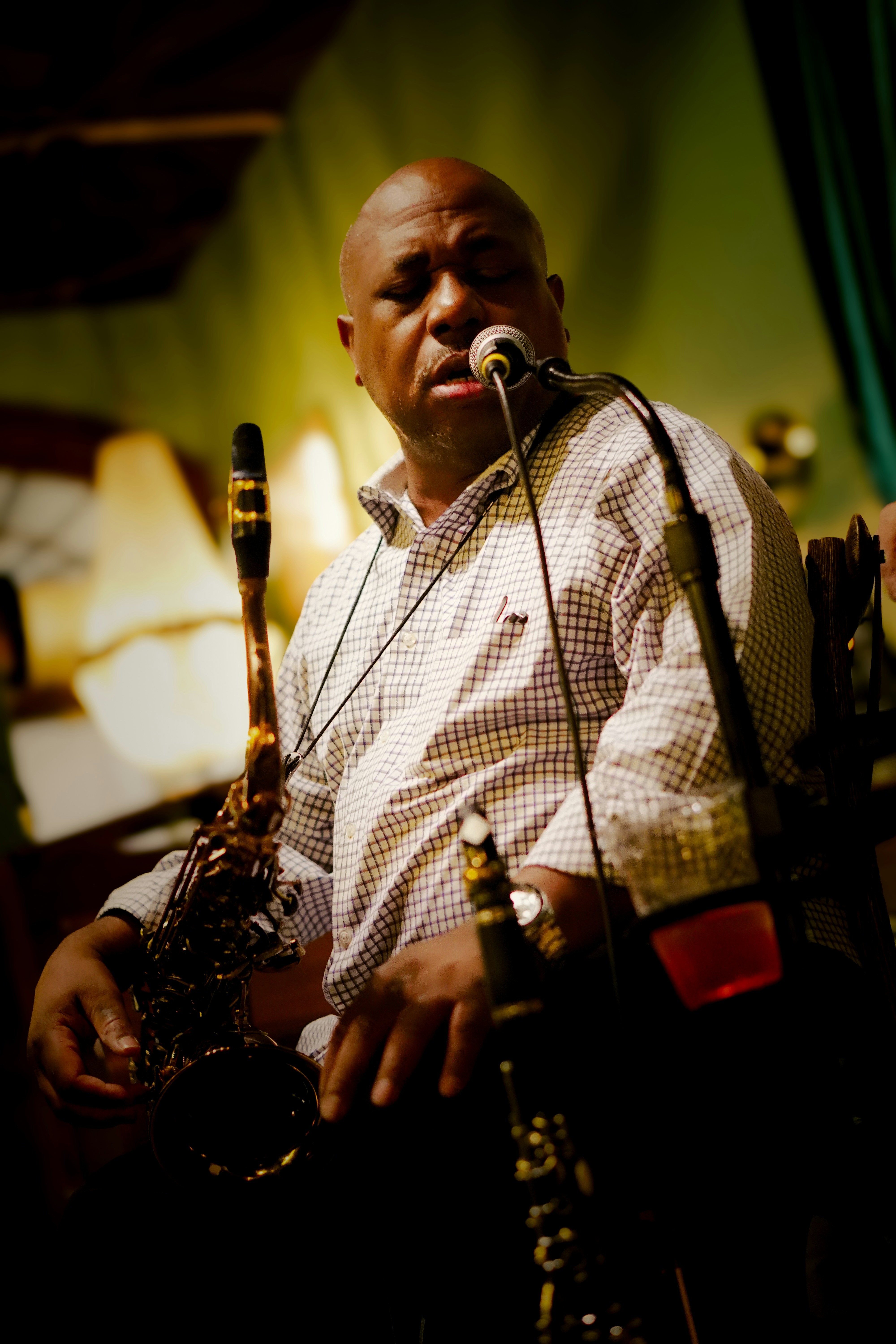 A man playing a musical instrument in front of a microphone