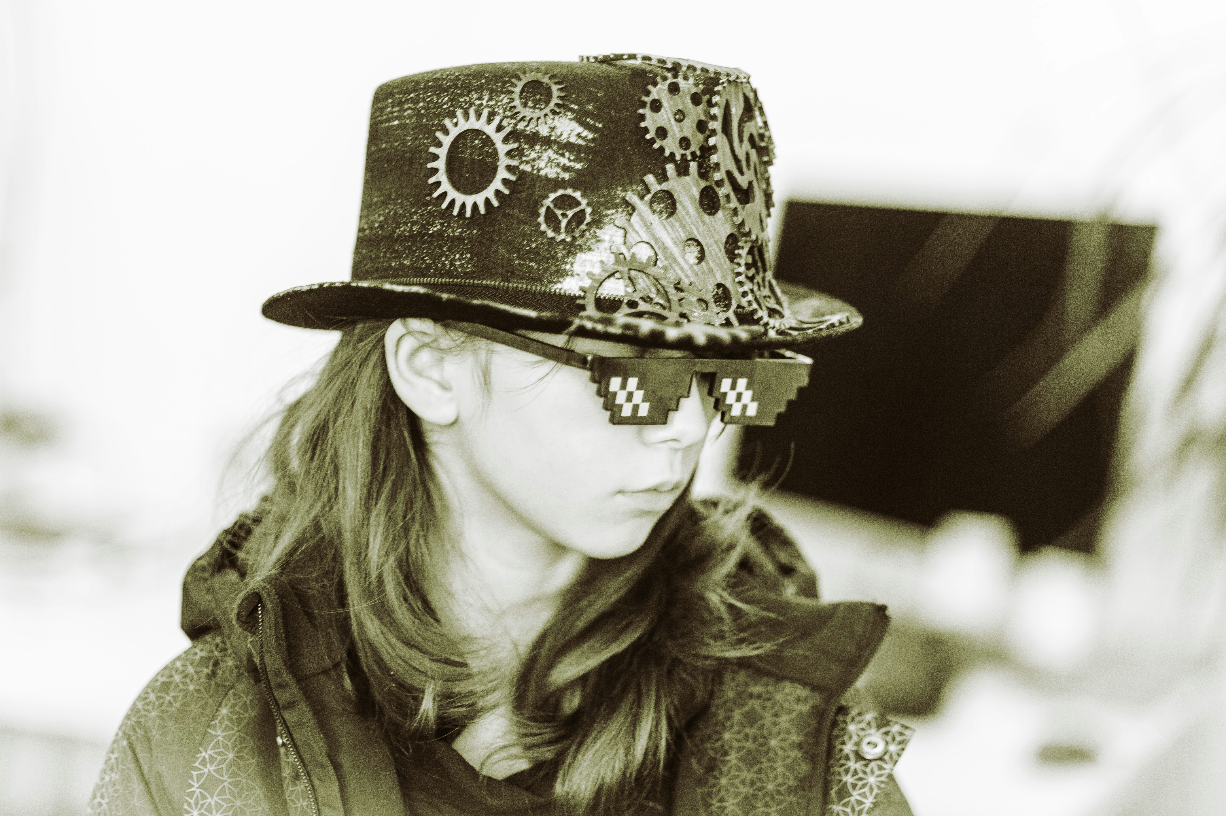 Fotomural A woman wearing a hat and sunglasses looking at her cell phone