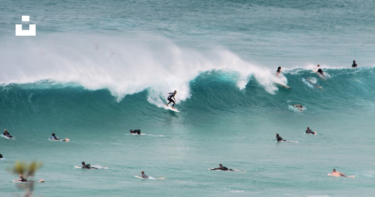 A group of people riding waves on top of surfboards photo – Free Nature ...