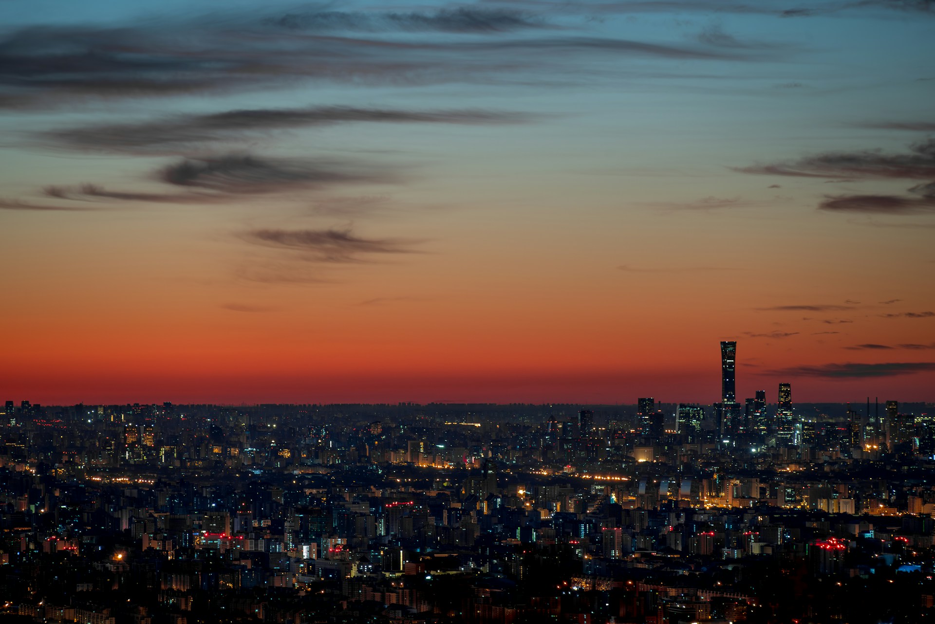 A view of a city at night from the top of a hill
