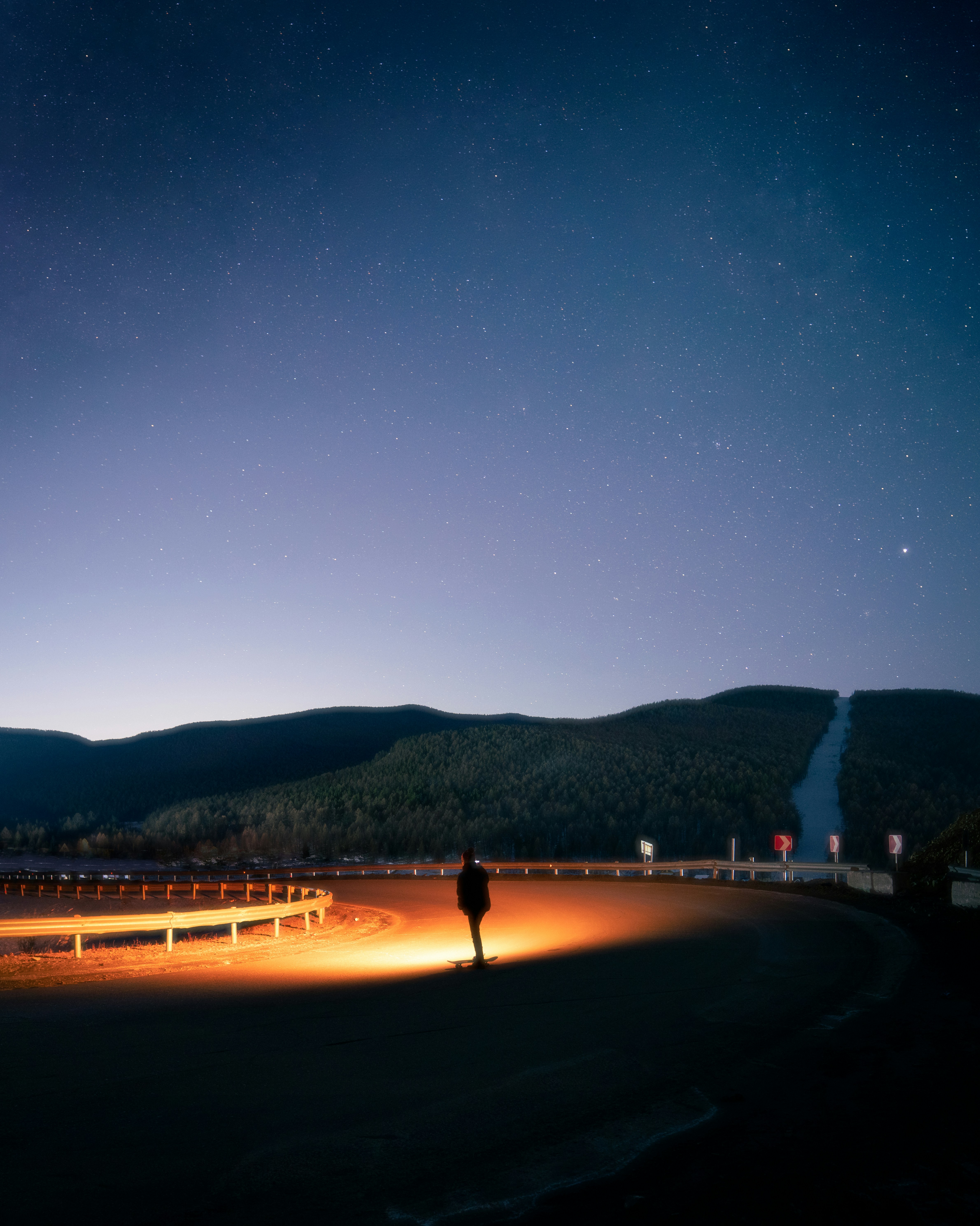 A person standing in the middle of a field at night
