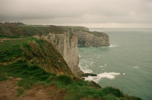 A cliff overlooking the ocean on a cloudy day