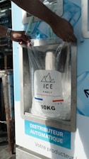 A person putting a bag of ice into a machine