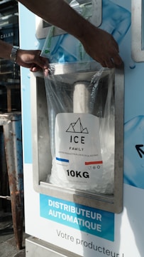 A person putting a bag of ice into a machine