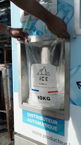 A person putting a bag of ice into a machine