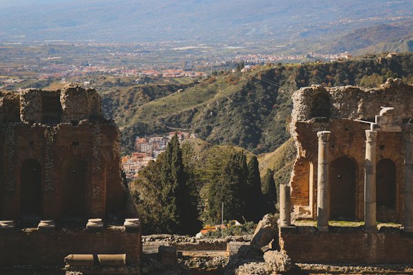 The brick arches of the Greek theatre at Taormina, open to the hills behind