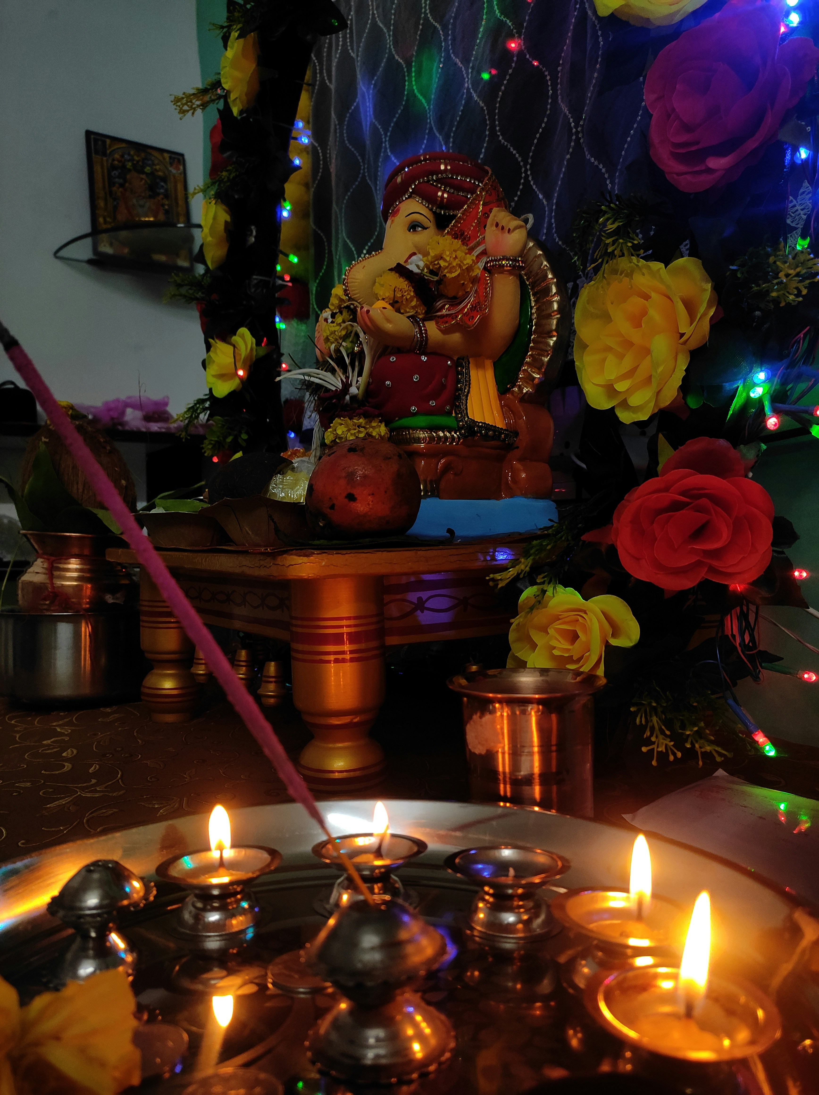 Colorful Ganesha idol decorated with flowers and lights during festival celebration
