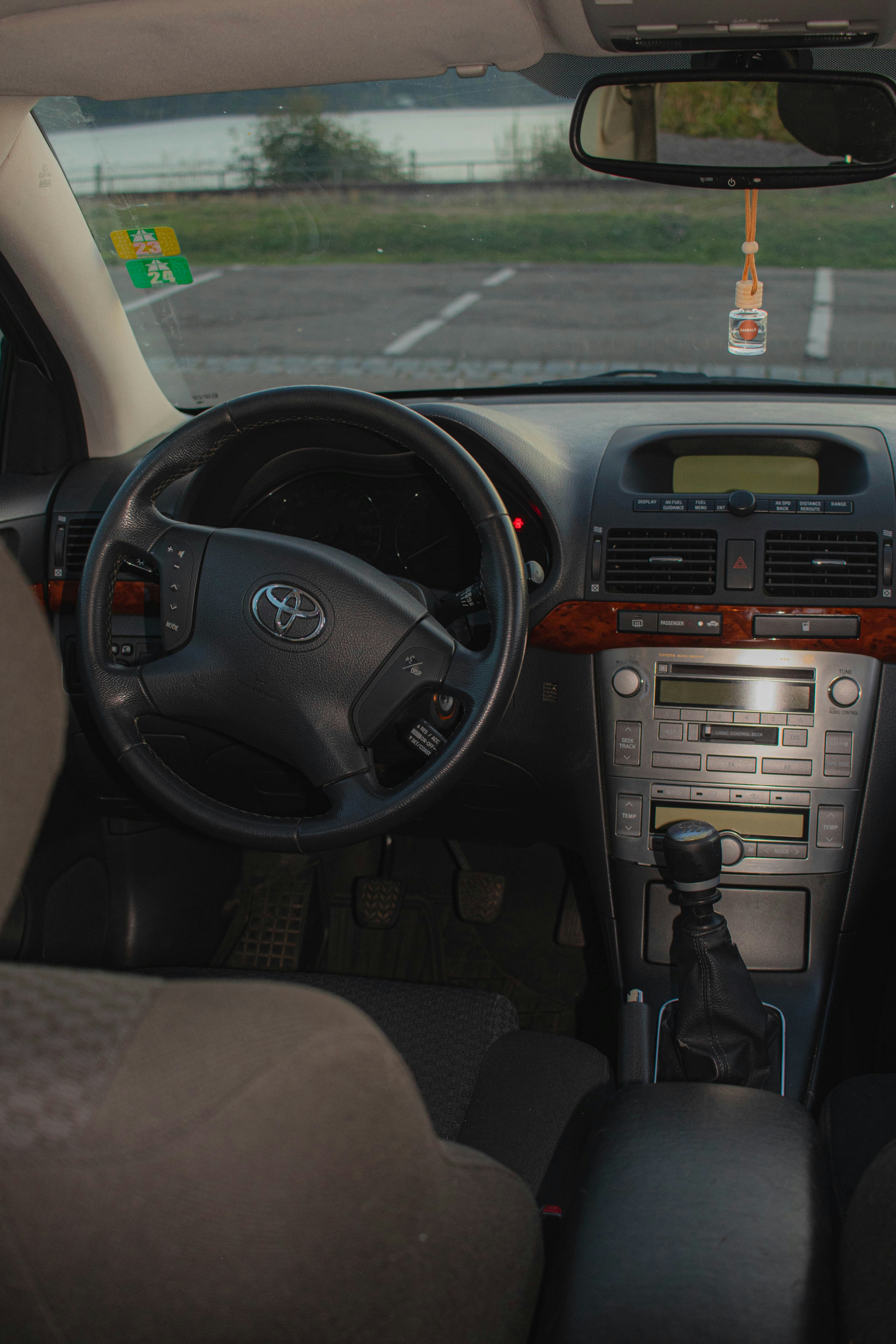 The dashboard of a car with a view of a parking lot
