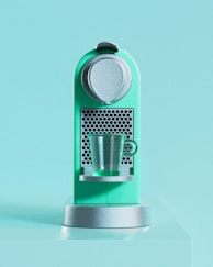 A green machine with a cup on top of it