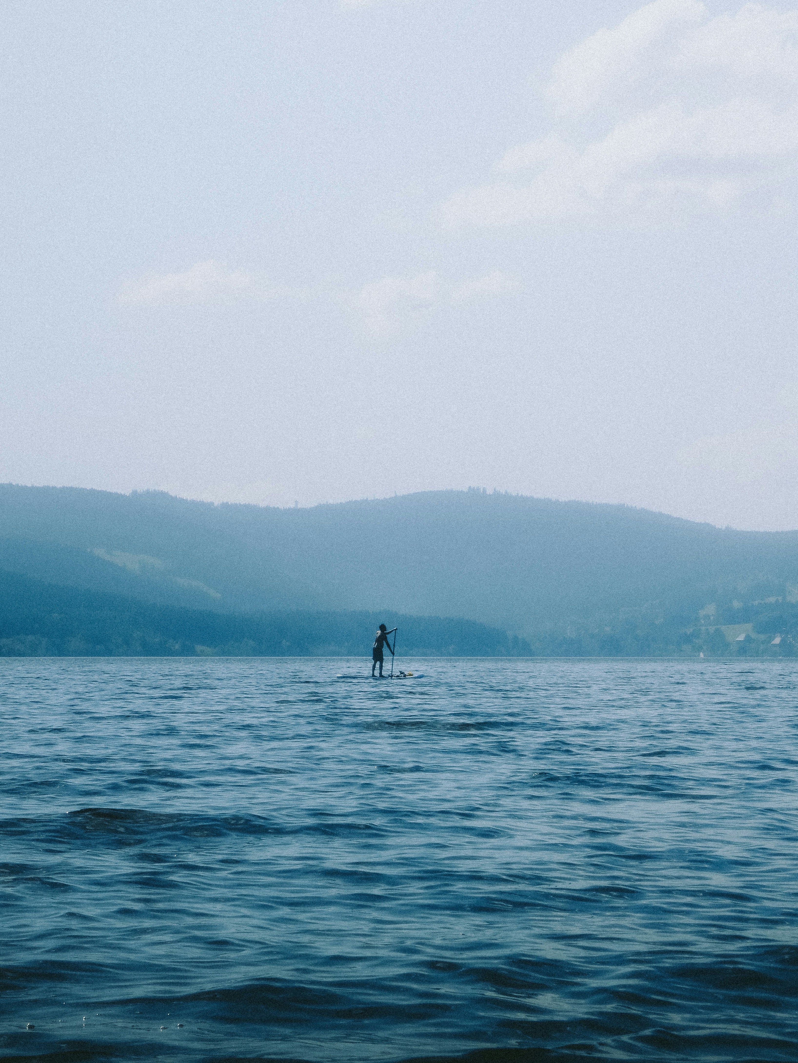 A person standing on a surfboard in the middle of a body of water