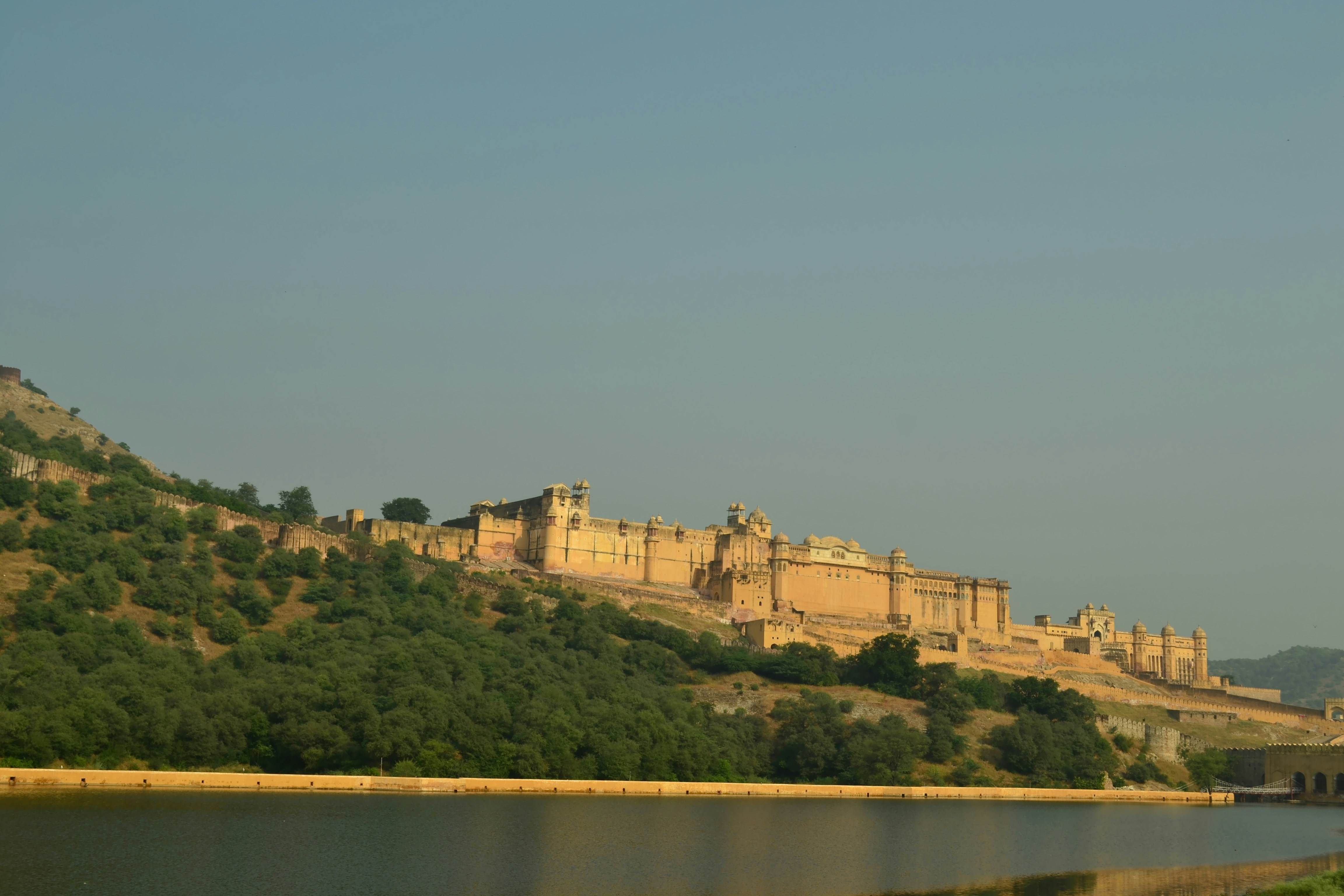 A castle on top of a hill next to a body of water