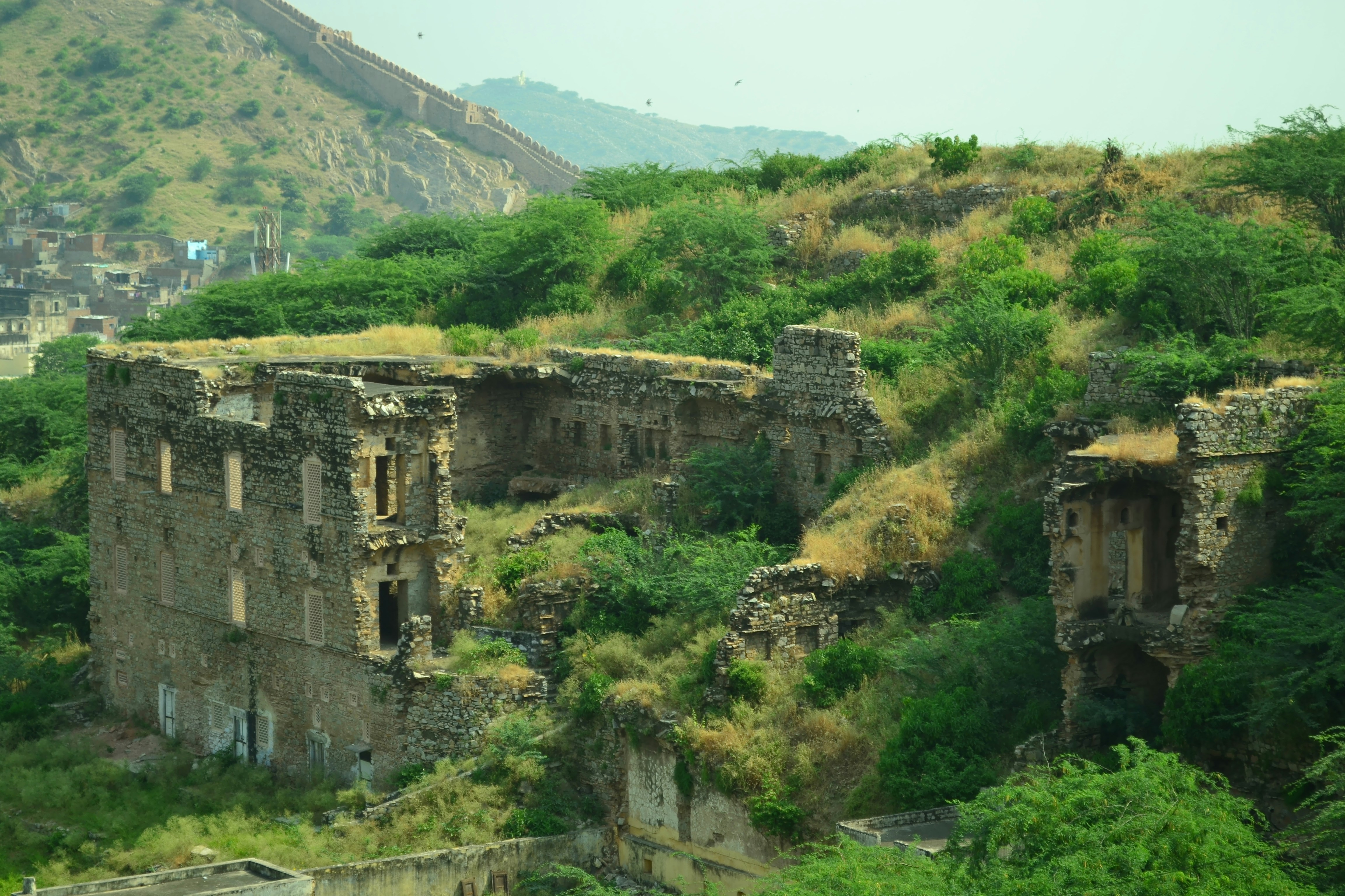 An old building on a hill with a mountain in the background