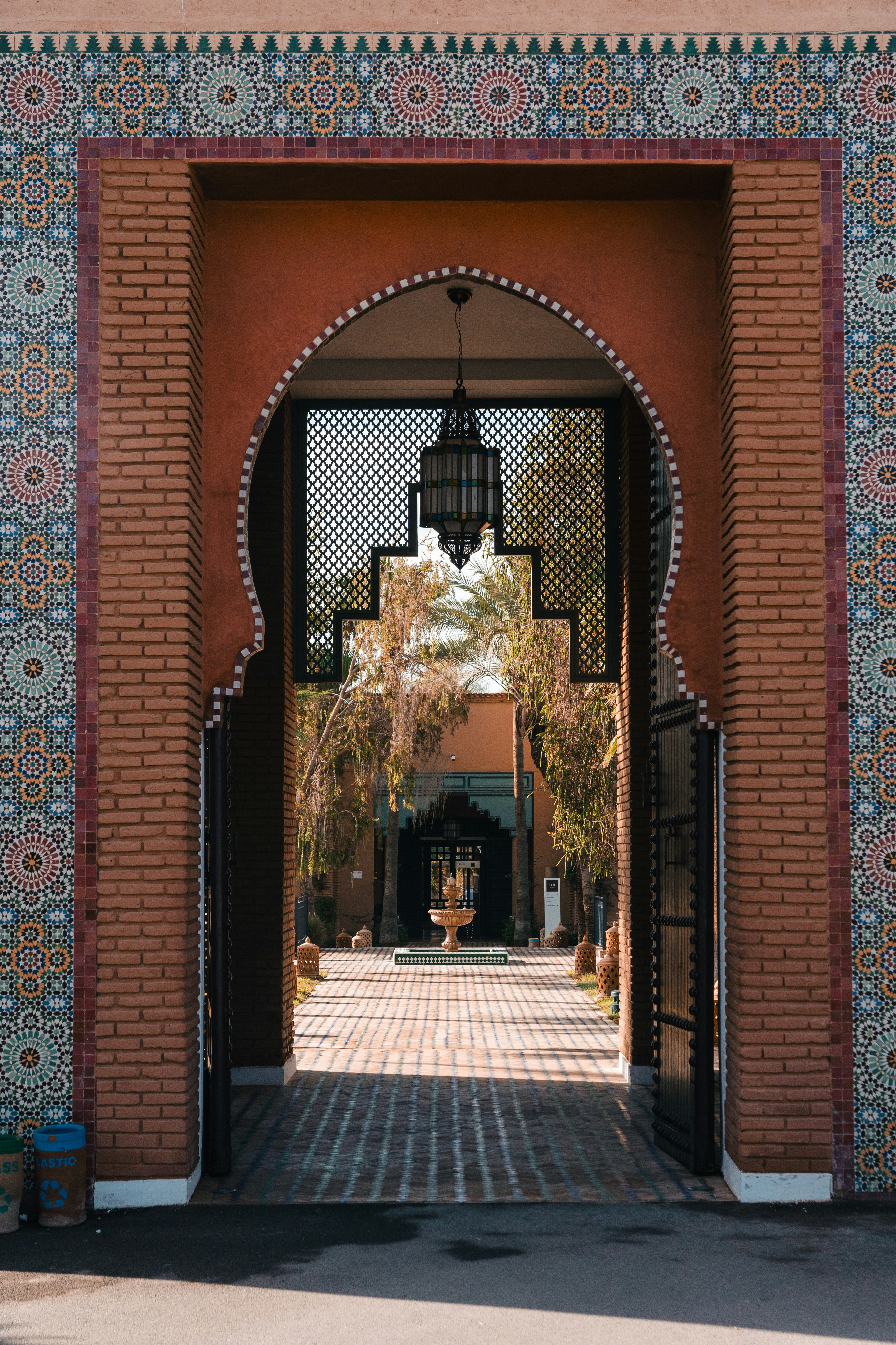 Patio d'un riad de Marrakech, arcades en pisé et lumière dorée du matin