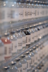 Bottles of water are lined up on a shelf