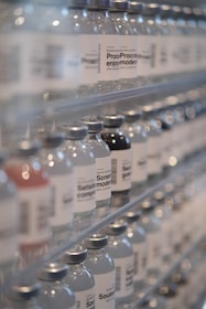 Bottles of water are lined up on a shelf
