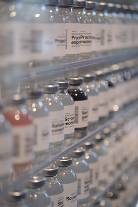 Bottles of water are lined up on a shelf