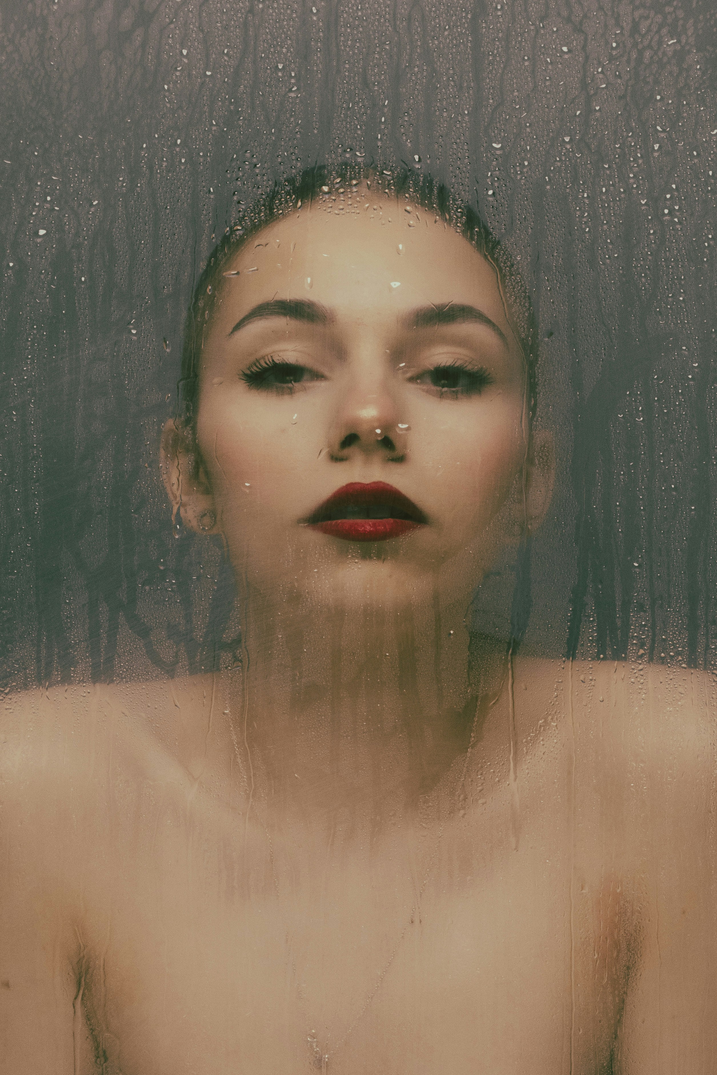 Une femme aux lèvres rouges debout devant une douche