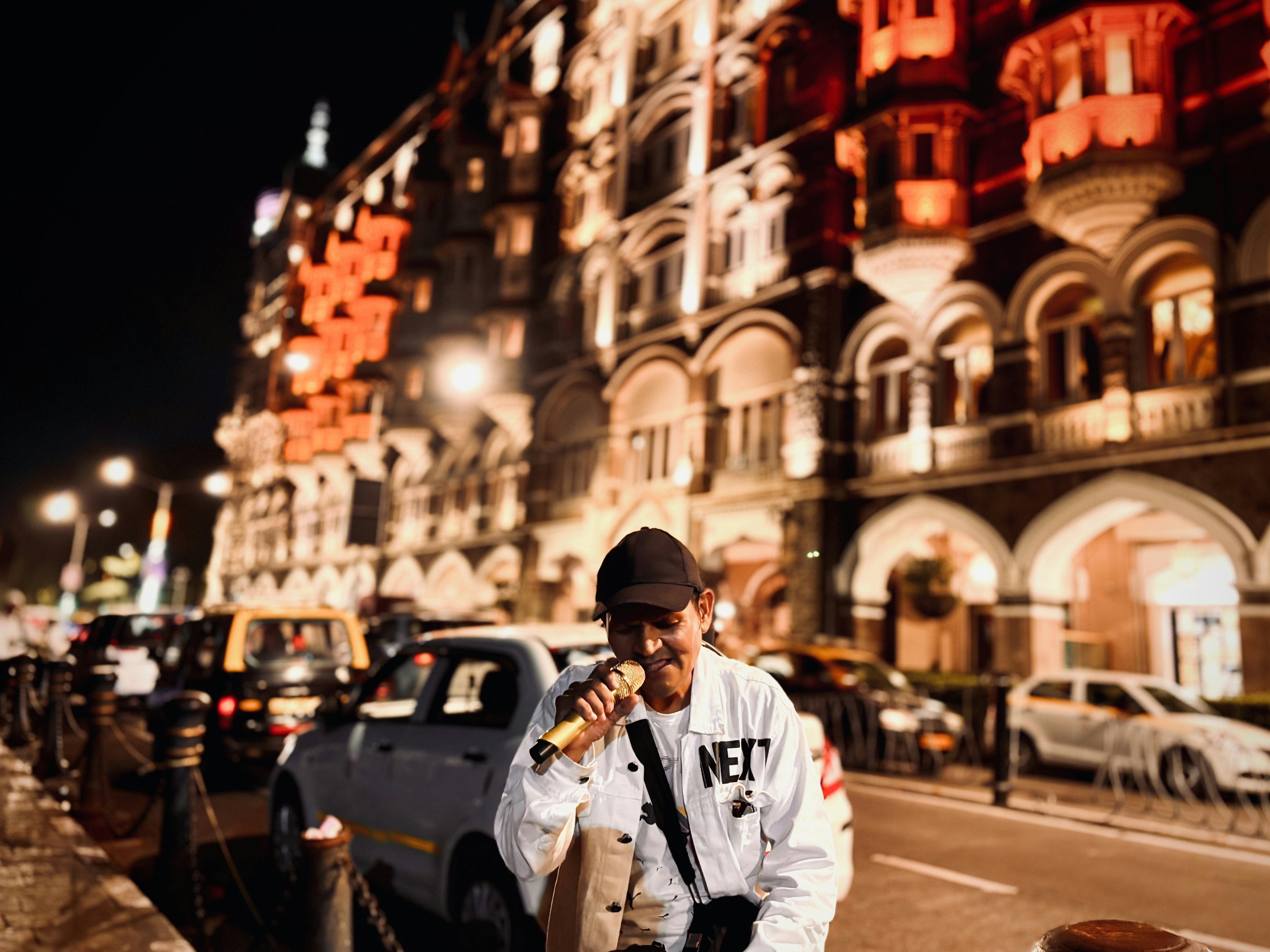 A man standing on the side of a street next to a car