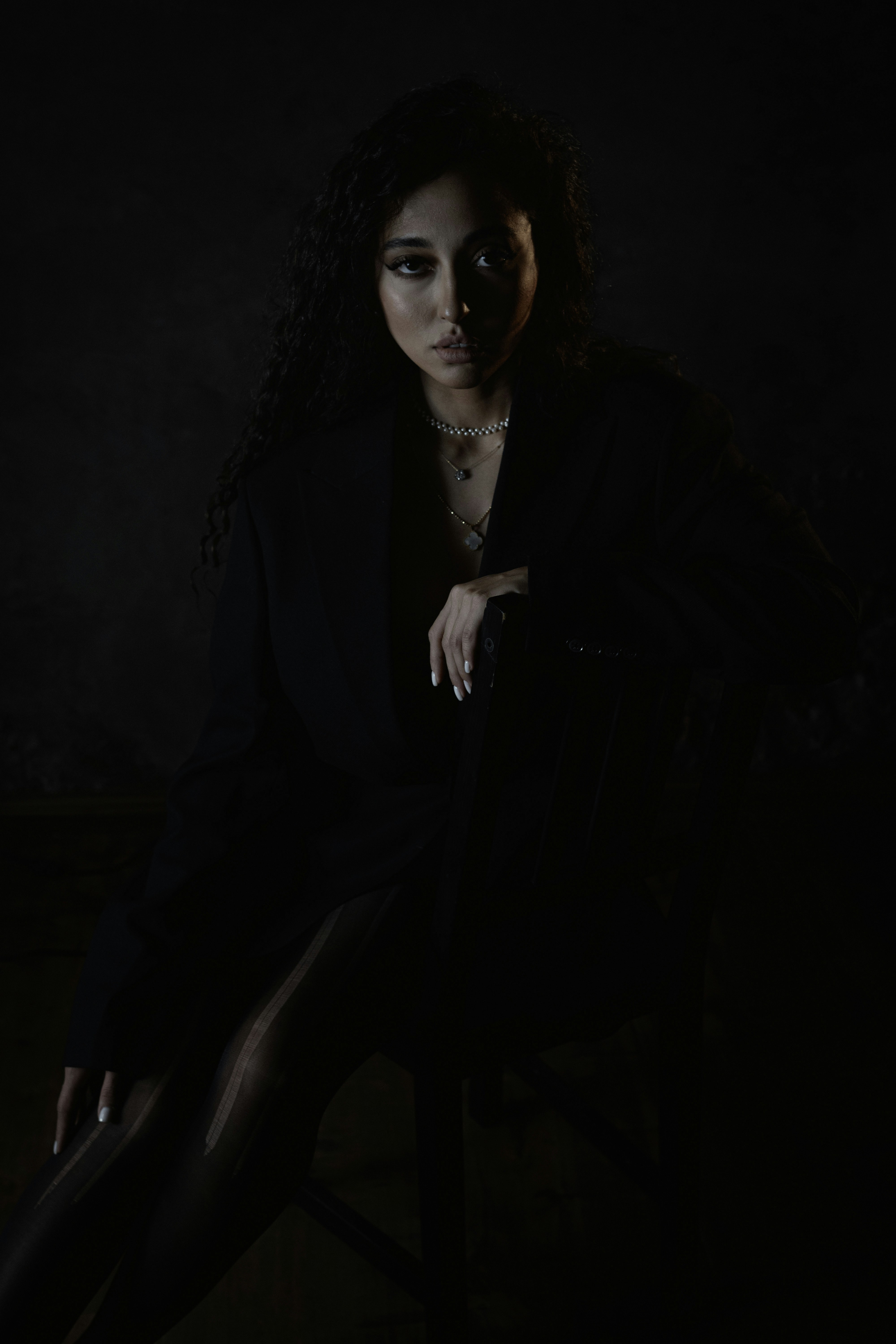 A woman sitting in a chair in a dark room