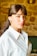 A woman wearing a white shirt and earrings