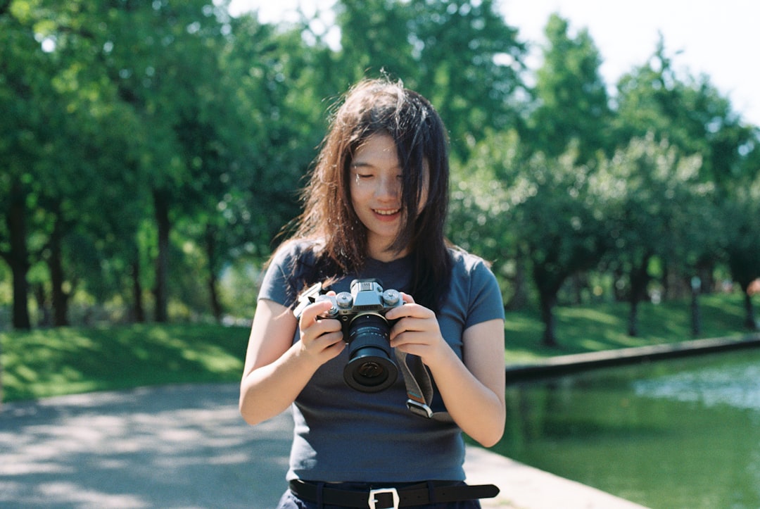 A woman taking a picture of herself with a camera, Shot by Nikon F3 with Kodak Gold 200