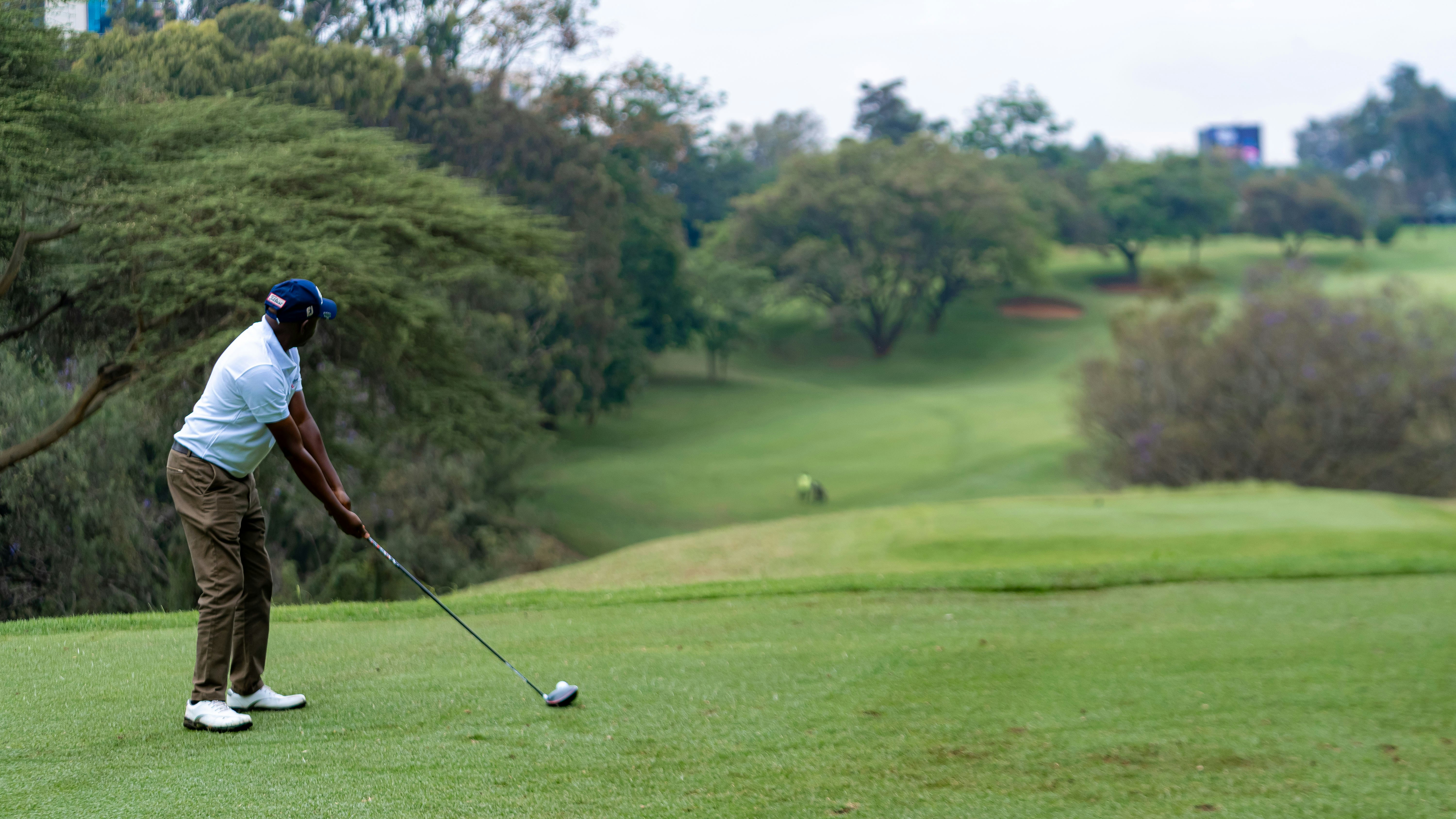 A man hitting a golf ball on a golf course